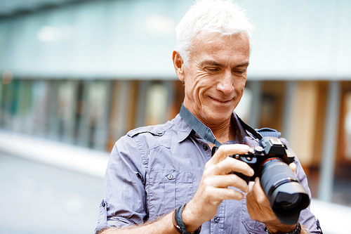 Senior man with camera in city