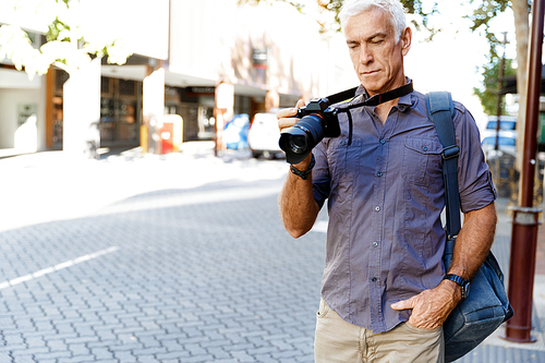 Senior man with camera in city