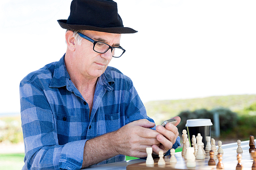 Portrait of an old man with his mobile phone outdoors