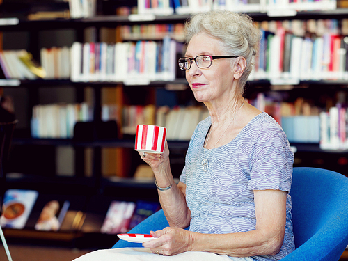 Elderly lady in the libary with cup of tea