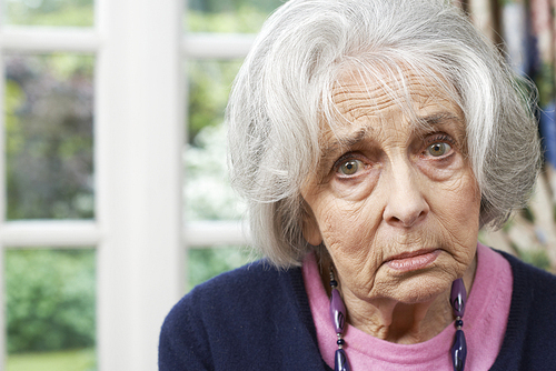 Head And Shoulders Portrait Of Unhappy Senior Woman At Home