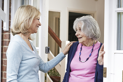 Woman Checking On Elderly Female Neighbor