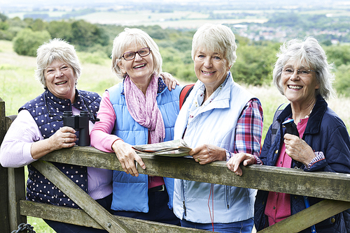 Group Of Senior Female Friends Hiking In Countryside