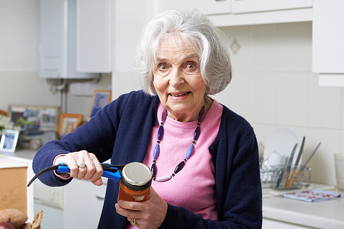 Senior Woman Taking Lid Off Jar With Kitchen Aid