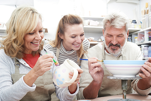Mature Couple With Teacher In Pottery Class