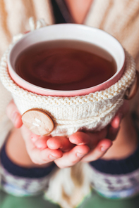 Woman is holding a cup of hot tea