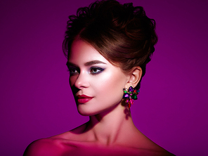 Brunette Girl with Elegant Curly Hairstyle. Beautiful Model woman with beautiful precious earring. Care and Beauty Hair products. Perfect Make-Up and Jewelry. Dramatic Purple Background