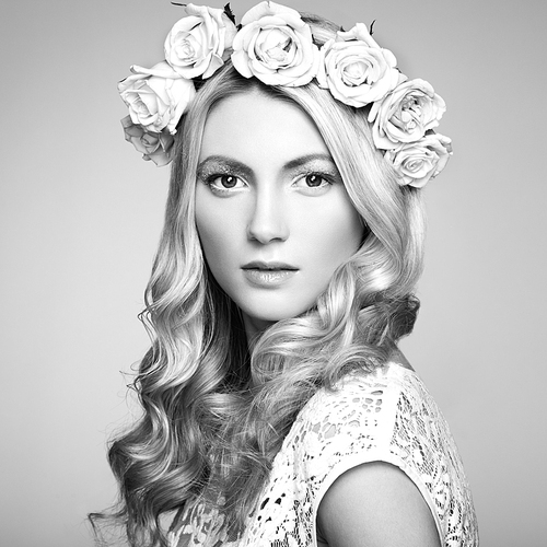 Portrait of a beautiful blonde woman with flowers in her hair. Fashion photo