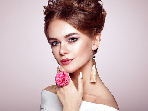 Brunette Woman with Elegant and shiny Hairstyle. Beautiful Model Woman with Curly Hairstyle. Care and Beauty Hair products. Perfect Make-Up. Nails and Manicure