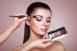 Makeup Artist applies Eye Shadow. Beautiful Woman Face. Perfect Makeup. Make-up detail. Beauty Girl with Perfect Skin. Nails and Manicure. Eye Shadow Palette