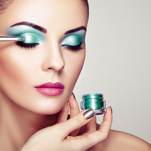Makeup Artist Applies Eye shadow. Beautiful Woman Face. Perfect Makeup. Makeup detail. Beauty girl with Perfect skin. Nails and Manicure