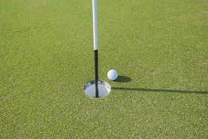 Golf ball at edge of hole