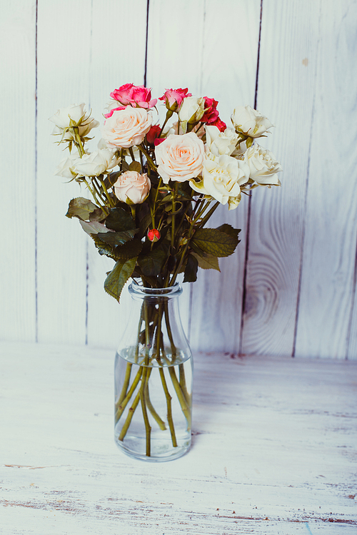 Luxury bouquet of roses lying over wooden wall. Copy space
