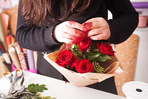 Florist making fashion bouquet of beautiful red roses