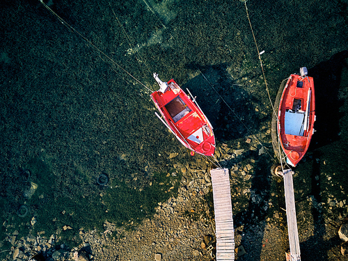 Wooden pier with fishing boats top aerial view drone shot, Sithonia, Greece