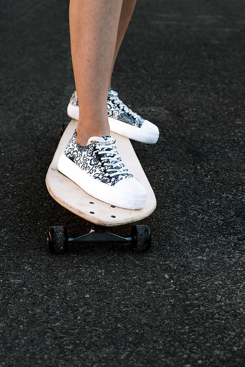 Front view of woman skateboarder legs with copyspace, skateboarding at sunrise city retro color