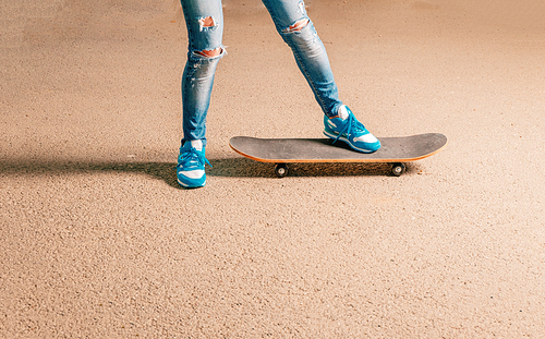 Legs of sporty woman on skateboard a lot of copyspace