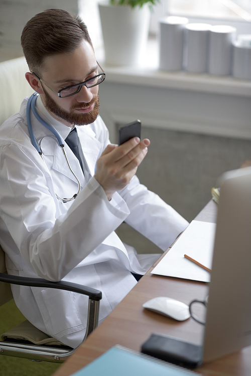Doctor texting on his smartphone