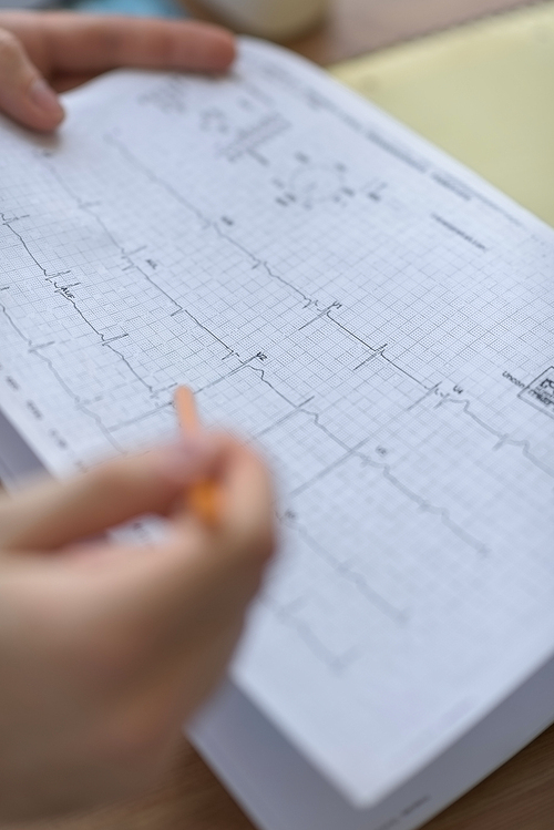 Confident practitioner consulting woman in hospital. Reading ecg results