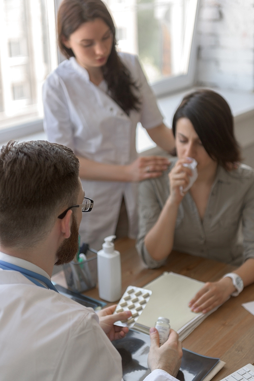 At doctor office. Doctor talking to patient after tests. Nurse standing near patient