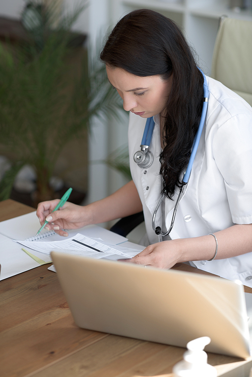 Doctor analyzing medical test results of her patient at her office