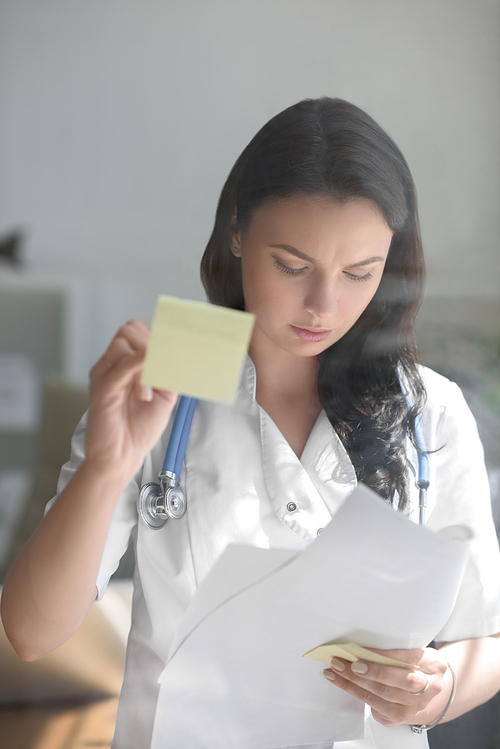 Doctor working at office with patient symptoms and test results