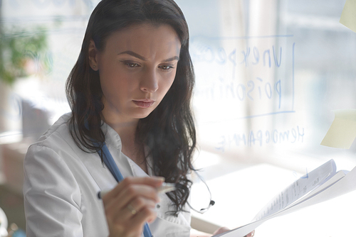 Doctor working at office with patient symptoms and test results