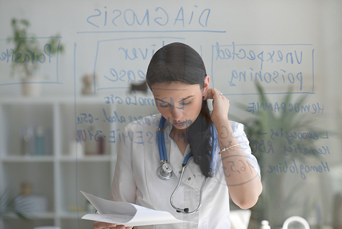 Doctor working at office with patient symptoms and test results