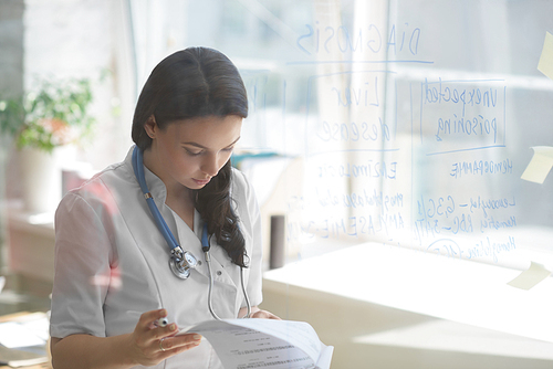 Doctor working at office with patient symptoms and test results