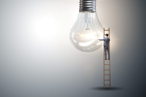 Businessman on ladder with light bulb