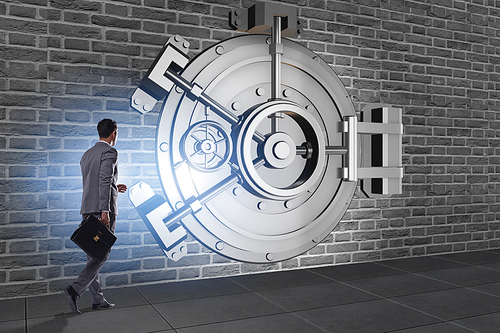 Businessman in front of banking vault door