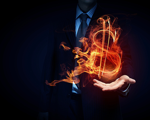 Burning dollar sign in businessman palm on dark background