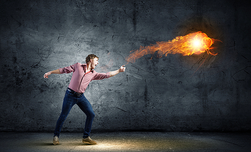 Young man in casual throwing magic fire balls