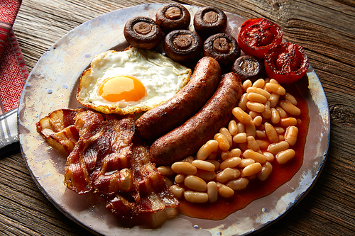 English breakfast with sausages egg beans bacon mushrooms and grilled tomato