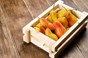 Wooden crate with organic pears on the table