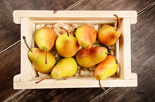 Wooden crate with organic pears on the table