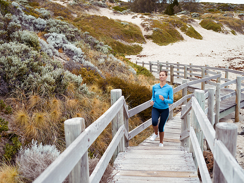 Sporty young woman running up the stairs