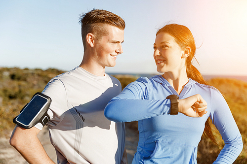 Young runner woman with heart rate monitor standing with her partner