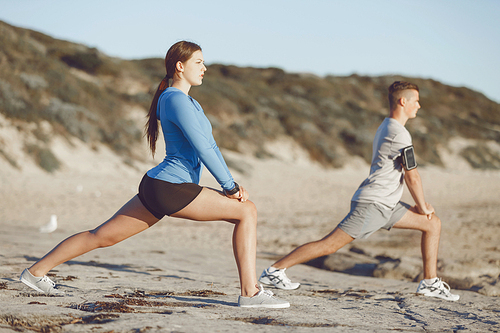 Young couple on beach training and exercising together
