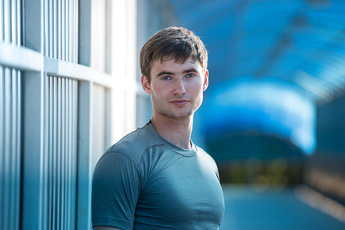 Jogger resting after running. Man runner taking a break during training outdoors in city. Young Caucasian male fitness model after work out.