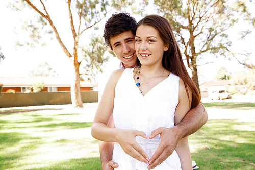 Young couple in the park and heart symbol