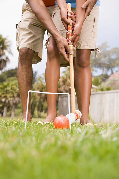 Two people playing croquet