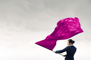 Determined businesswoman waving flag as symbol of women power