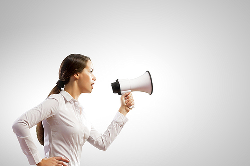 Image of young businesswoman screaming in megaphone