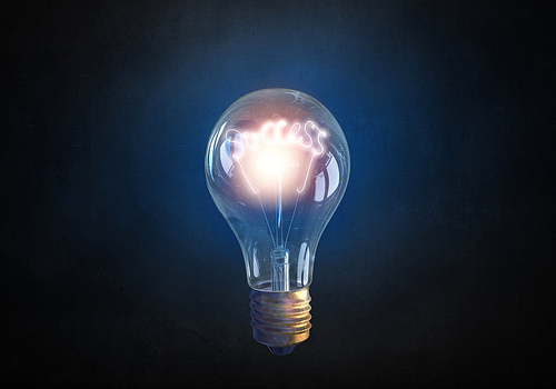 Glowing glass light bulb on concrete background