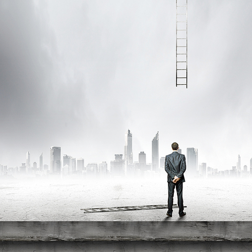 Rear view of businessman looking at broken ladder