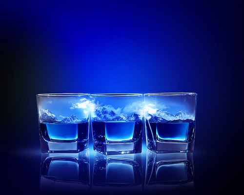 Three glasses of blue liquid with mountain illustration in