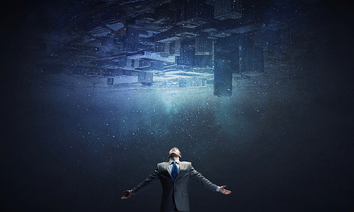 Businessman with hands spread apart and city reflection in sky