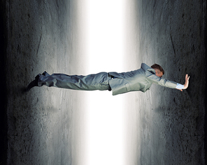 Businessman under pressure between two stone walls