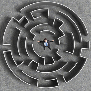 Top view of businessman standing in center of labyrinth
